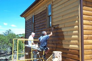 doug & Mick staining logs outside