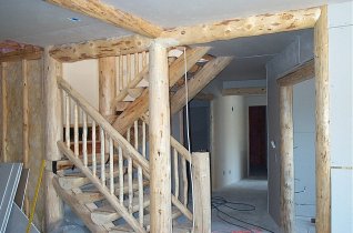 stairs and hallway showing the drywall and logs