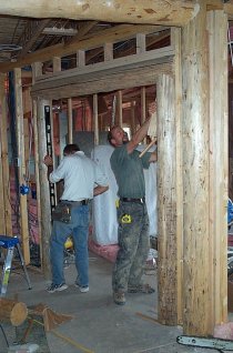Mick & Ben erecting a log arch in the office doorway